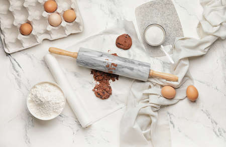 Cookies and rolling pin on light background