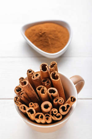 Cup with cinnamon sticks on table