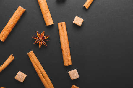 Cinnamon sticks, sugar and anise on dark backgroundの写真素材