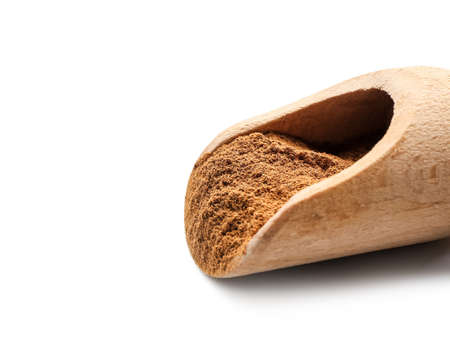 Scoop with cinnamon powder on white background, closeupの写真素材