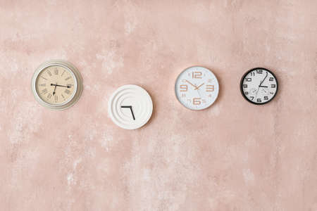 Different clocks hanging on color wallの写真素材