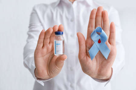 Woman with awareness ribbon and insulin on white background, closeup. Diabetes concept