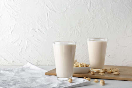 Glasses of different vegan milk on light backgroundの写真素材