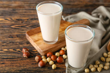 Glasses of tasty hazelnut milk on dark wooden backgroundの写真素材