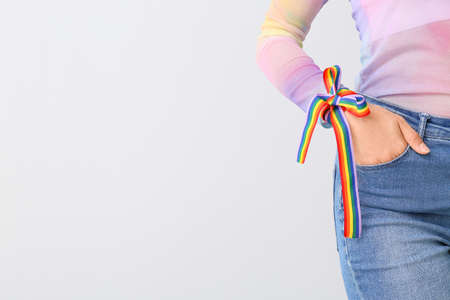 Young woman with rainbow strip on light background. LGBT conceptの写真素材