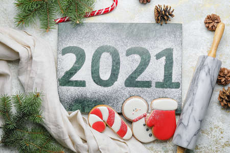 Tasty Christmas cookies, rolling pin and text 2021 on light backgroundの写真素材