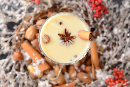 Tasty milkshake with cinnamon in glass, top view
