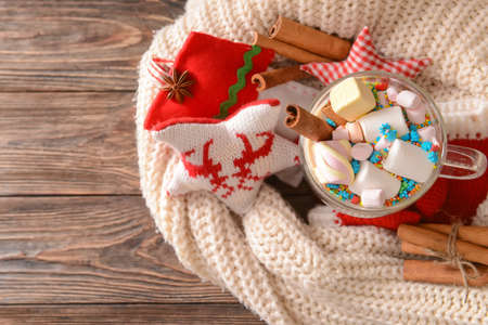 Tasty hot cocoa with cinnamon and marshmallows in cup on tableの写真素材