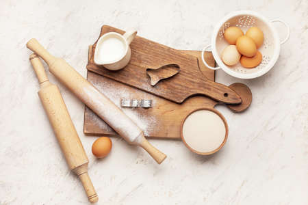 Ingredients for cookies and rolling pins on light backgroundの写真素材
