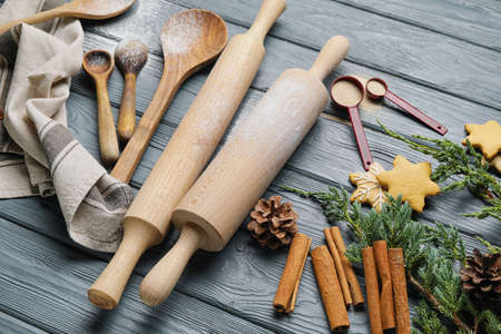 Cookies, cinnamon and rolling pins on wooden background