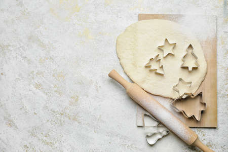 Cookie cutters, dough and rolling pin on light backgroundの写真素材