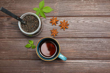 Cup of hot tea and dry leaves on wooden backgroundの写真素材