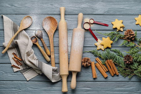 Cookies, cinnamon and rolling pins on wooden background