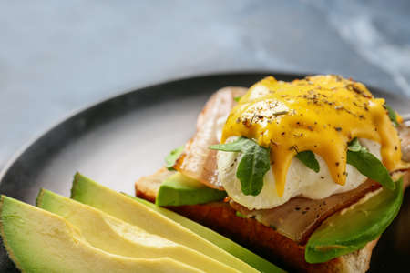 Plate with tasty egg Benedict on table, closeup