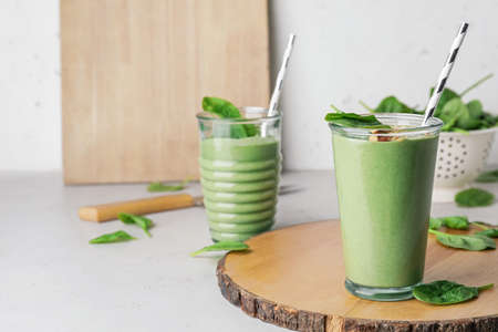 Glasses of healthy spinach smoothie on light tableの写真素材