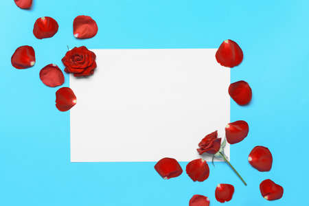 Beautiful rose petals and blank paper on color backgroundの写真素材