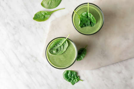 Glasses of healthy spinach smoothie on light backgroundの写真素材