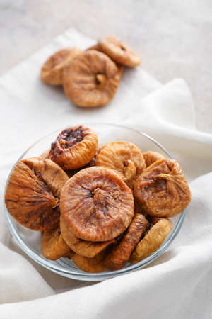 Bowl with tasty dried figs on table