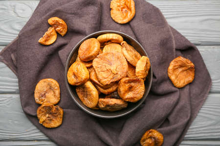Bowl with tasty dried figs on wooden backgroundの写真素材
