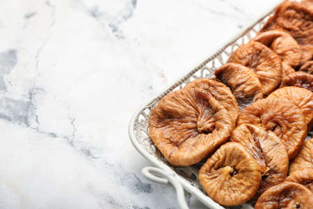 Tray with tasty dried figs on tableの写真素材