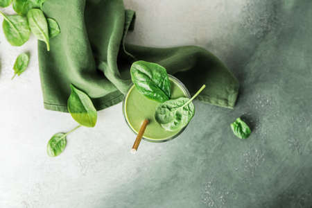 Glass of healthy spinach smoothie on color backgroundの写真素材