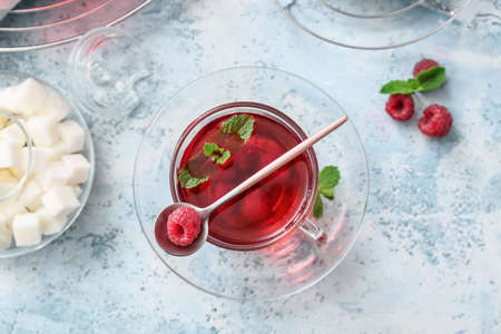 Cup of hot tea with berries on color backgroundの写真素材