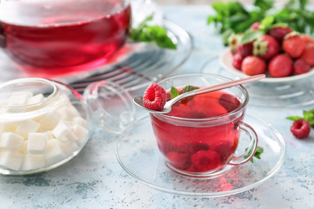 Cup of hot tea with berries on color backgroundの写真素材