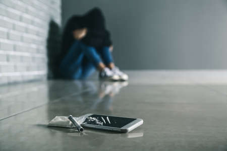 Mobile phone, drugs and banknote on floorの写真素材