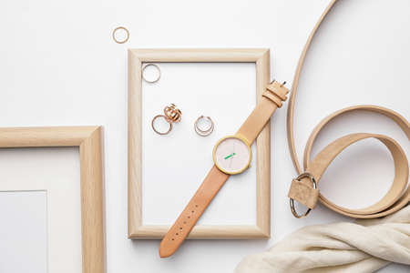 Stylish wristwatch, blank photo frame and rings on light backgroundの写真素材