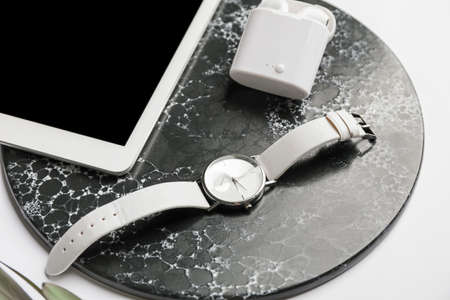 Stylish wristwatch, tablet computer and earphones on light backgroundの写真素材