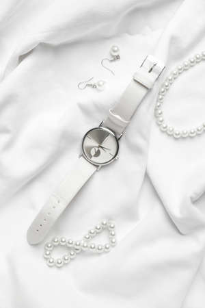 Stylish wristwatch and jewelry on light backgroundの写真素材