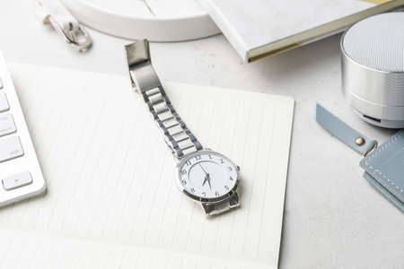 Stylish wristwatch and notebook on light backgroundの写真素材
