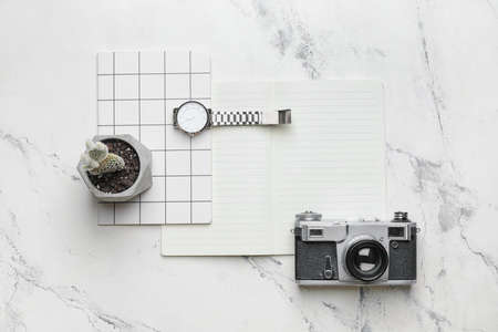 Stylish composition with wristwatch, notebooks and photo camera on light backgroundの写真素材