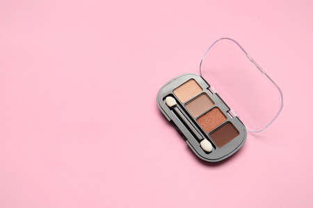 Beautiful palette of eyeshadows on color background