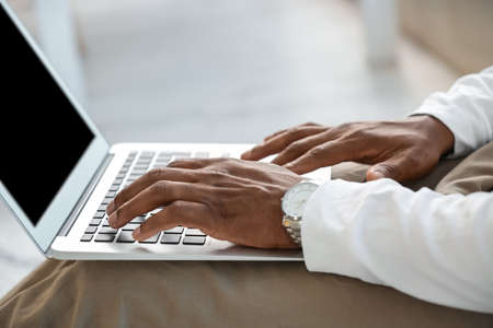 African-American man working on laptop at home, closeupの写真素材