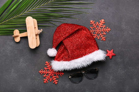 Composition with Santa Claus hat, sunglasses and airplane on dark backgroundの写真素材
