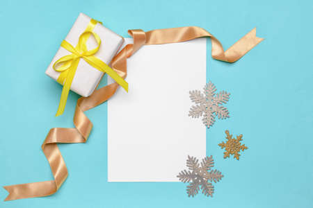Beautiful Christmas gift with empty card on color background