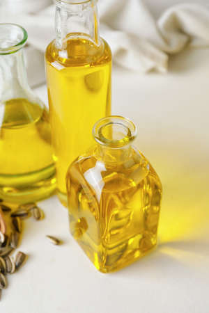 Bottles of oil and seeds on light backgroundの写真素材