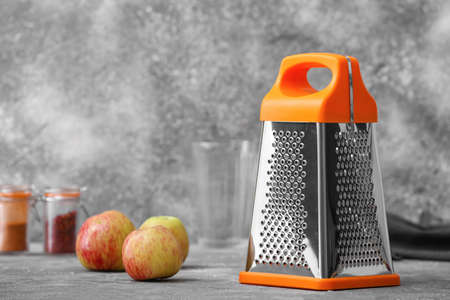 Metal grater and apples on grunge backgroundの写真素材