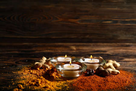 Burning candles with spices and nuts for celebration of Divaly on wooden backgroundの写真素材
