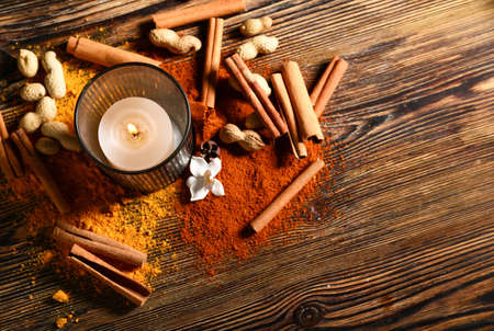 Burning candle with spices and nuts for celebration of Divaly on wooden backgroundの写真素材
