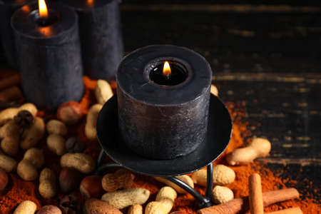 Burning candles with spices and nuts for celebration of Divaly on wooden background