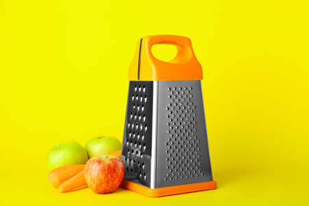 Metal grater, apples and carrots on color backgroundの写真素材