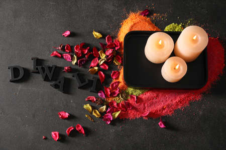 Burning candles and flower petals for celebration of Diwali on dark background