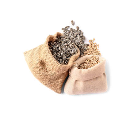 Bags with sunflower seeds on white background