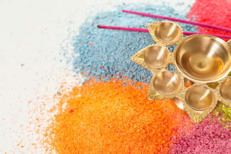 Diya lamp with aroma sticks and colorful powder for celebration of Divaly on white backgroundの写真素材