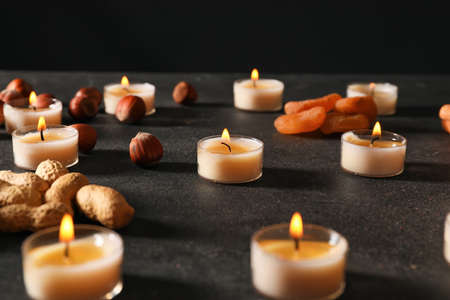 Burning candles with treats for celebration of Divaly on dark backgroundの写真素材