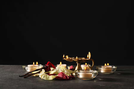 Festive composition with diya lamp for celebration of Divaly on dark background