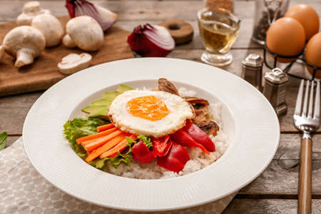 Plate with tasty egg, vegetables and rice on wooden backgroundの写真素材