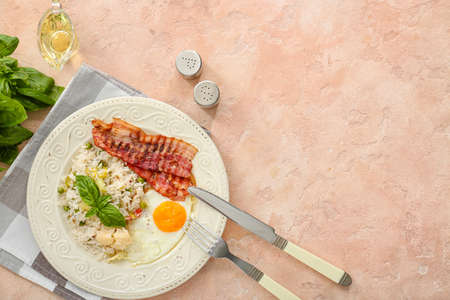 Plate with tasty egg, bacon and rice on color backgroundの写真素材